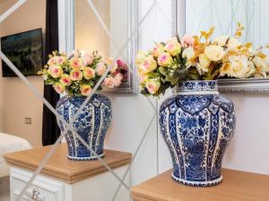 due vasi bianchi e blu seduti su un tavolo con fiori di Paradise Center Premium Suite 2 a Sofia