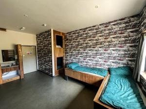 Habitación con 2 camas y pared de ladrillo en Adventure Lodges and Retreats en Bideford