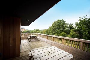 a deck with a bench and a picnic table on it at Adventure Lodges and Retreats in Bideford