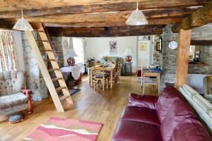 a living room with a couch and a dining room at Glanyrafon Smithy Talgarreg in Tal-gareg