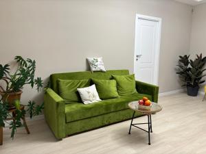 a green couch in a living room with a table at RestArt Boutique Hotel in Dilijan