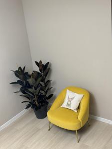a yellow chair sitting next to a potted plant at RestArt Boutique Hotel in Dilijan