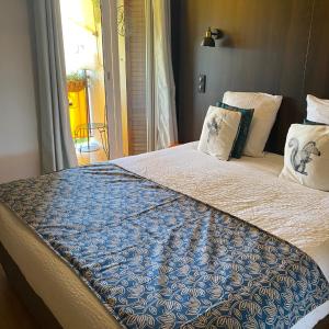 Una cama con una manta azul y blanca. en Rosie's Club en Ajaccio