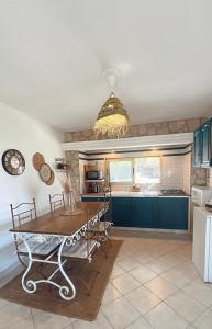 a kitchen with blue cabinets and a table at Villa Conception in Le Thoronet