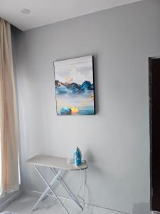 ein Bild hängt an einer weißen Wand mit einem Stuhl in der Unterkunft Modern Village Apartments in Chipata