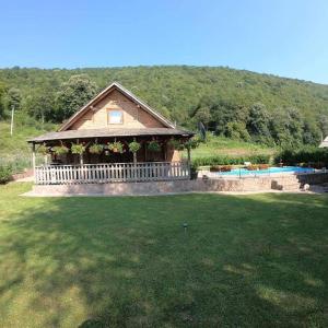una casa con una valla blanca y una piscina en "River paradise" Vikendica sa bazenom, ladarom i kaminom na samoj obali Vrbasa Banja Luka, en Banja Luka