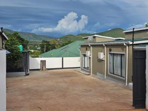 ein leerer Parkplatz neben einem Gebäude mit grünem Dach in der Unterkunft Modern Village Apartments in Chipata