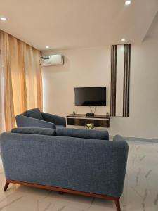 a living room with a couch and a flat screen tv at Modern Village Apartments in Chipata