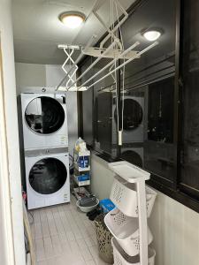 a laundry room with two washing machines and a sink at Memory - Internationals Only in Daegu