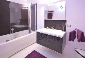 y baño blanco con lavabo y ducha. en Mar dei Poeti - Luxury Suites, en Riposto