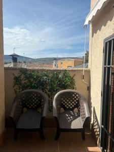 2 sillas sentadas en un balcón con vistas en Habitación intima con patio privado, 