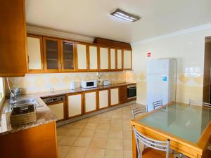 une cuisine avec des armoires en bois et un réfrigérateur blanc dans l'établissement Rafael by Check-in Portugal, à Albufeira