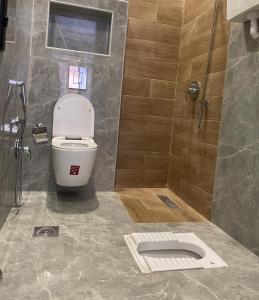 a bathroom with a toilet and a shower at شالية الفهد in Bawḑah
