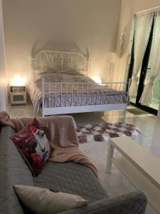 a bedroom with a bed and a couch in front of it at شالية الفهد in Bawḑah