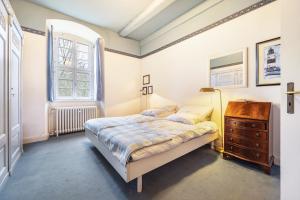 a bedroom with a bed and a dresser and a window at Wohnung Burggarten in Trendelburg