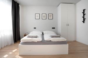 ein weißes Schlafzimmer mit einem Bett mit zwei Kissen in der Unterkunft Schicke Apartments in Bonn I home2share in Bonn