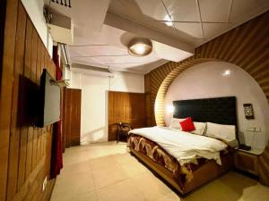 a bedroom with a bed in a room with a tv at Ganga Hotel Near Mall Road in Shimla