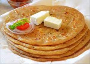a stack of pancakes with cheese and tomatoes on top at Ganga Hotel Near Mall Road in Shimla