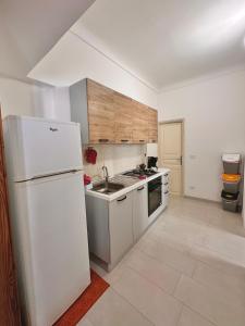 uma cozinha com um frigorífico branco e um lavatório em Al Barocco em Sortino