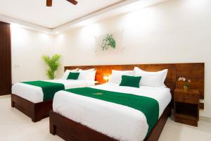 um quarto com 2 camas com lençóis verdes e brancos em Jardin Colonial Boutique Hotel em Santo Domingo