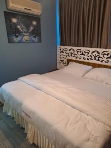 sypialnia z dużym białym łóżkiem z zagłówkiem w obiekcie EVLAND CiTY SUiT w mieście Adana
