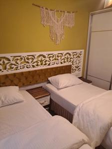 dwa łóżka w pokoju z dwoma łóżkami w obiekcie EVLAND CiTY SUiT w mieście Adana