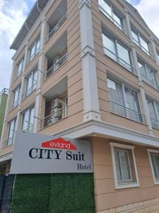 a building with a sign in front of it at EVLAND CiTY SUiT in Adana