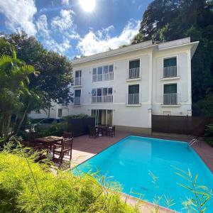 un hotel con piscina di fronte a un edificio di Pousada Magister a Petrópolis