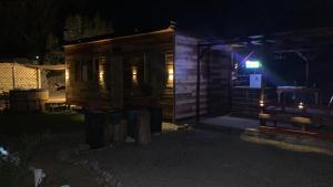 Cabaña de madera con un cartel iluminado por la noche en Tinyhouse Ecologico con Tinaja, en Villa Alemana