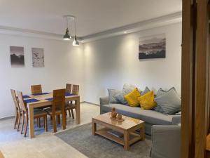 ein Wohnzimmer mit einem Sofa und einem Tisch in der Unterkunft MARTIL COSTA MAR Appartement de Luxe in Martil