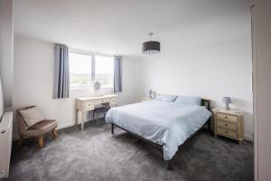 a bedroom with a bed and a desk and a chair at Harbour View Goodwick in Goodwick