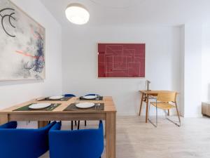 une salle à manger avec une table en bois et des chaises bleues dans l'établissement Holi-Rent Pobladores, à Camas