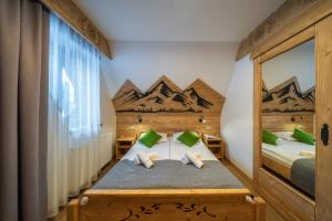 a bedroom with a bed with a mountain mural on the wall at Hotel Eco Tatry Holiday& Spa in Kościelisko