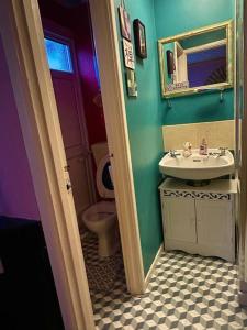 a blue bathroom with a sink and a toilet at Oriental Belle Aire in Hemsby +12 photos