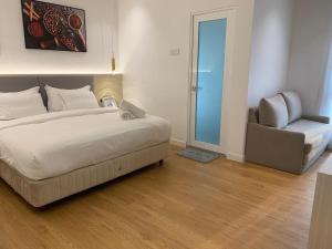 1 dormitorio con 1 cama grande y 1 silla en AP Concept Hotel en Petaling Jaya