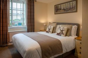 um quarto com uma cama grande e uma janela em Harts Head Hotel em Settle