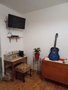 a living room with a guitar on the wall at E lu chantauziau in La Monnerie-le Montel