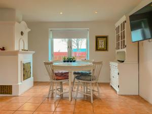 a kitchen with a table and chairs and a television at Kungshagagård in Höllviken