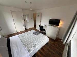 ロンドンにあるBethnal green homeのベッドルーム1室(ベッド1台、デスク、テレビ付)