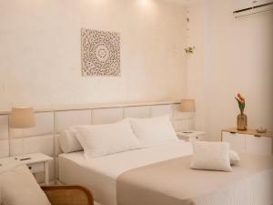 ein weißes Schlafzimmer mit einem Bett und einem Tisch in der Unterkunft Albergo Elea in Ascea