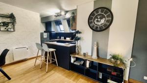 uma cozinha com um lavatório e um relógio na parede em Bel appartement au coeur du quartier des artistes em Camaret-sur-Mer
