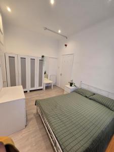 a bedroom with a bed with a green comforter at RELAKS LETTINGS in London