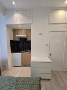 a kitchen with white cabinets and a white door at RELAKS LETTINGS in London