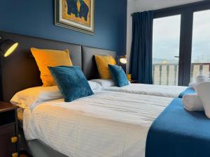 a bedroom with two beds with blue walls and a window at Villa Higer in Hondarribia