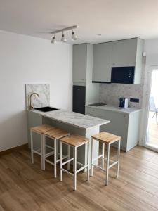 Una cocina con encimera y taburetes en una habitación. en Casa Da´Mar, en Marbella