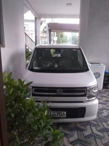 een witte auto geparkeerd in een garage bij TravelNest in Badulla