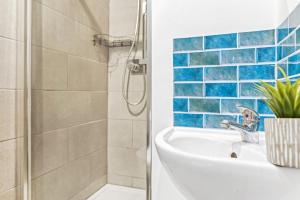 a bathroom with a sink and a shower with blue tiles at Luxurious 3 Bedroom Apartment in Park Estate in Nottingham