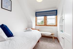 a bedroom with a white bed and a window at The Neuk 4 miles to St Andrews in Strathkinness