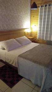 ein Schlafzimmer mit einem großen weißen Bett und einem Fenster in der Unterkunft Pousada Villa Fiorita in Canela