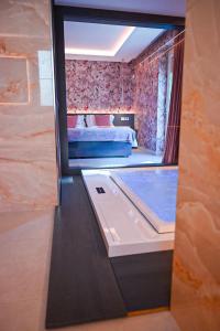 Zimmer mit Badewanne und Schlafzimmer mit Bett in der Unterkunft Masseria Elysium in Mesagne